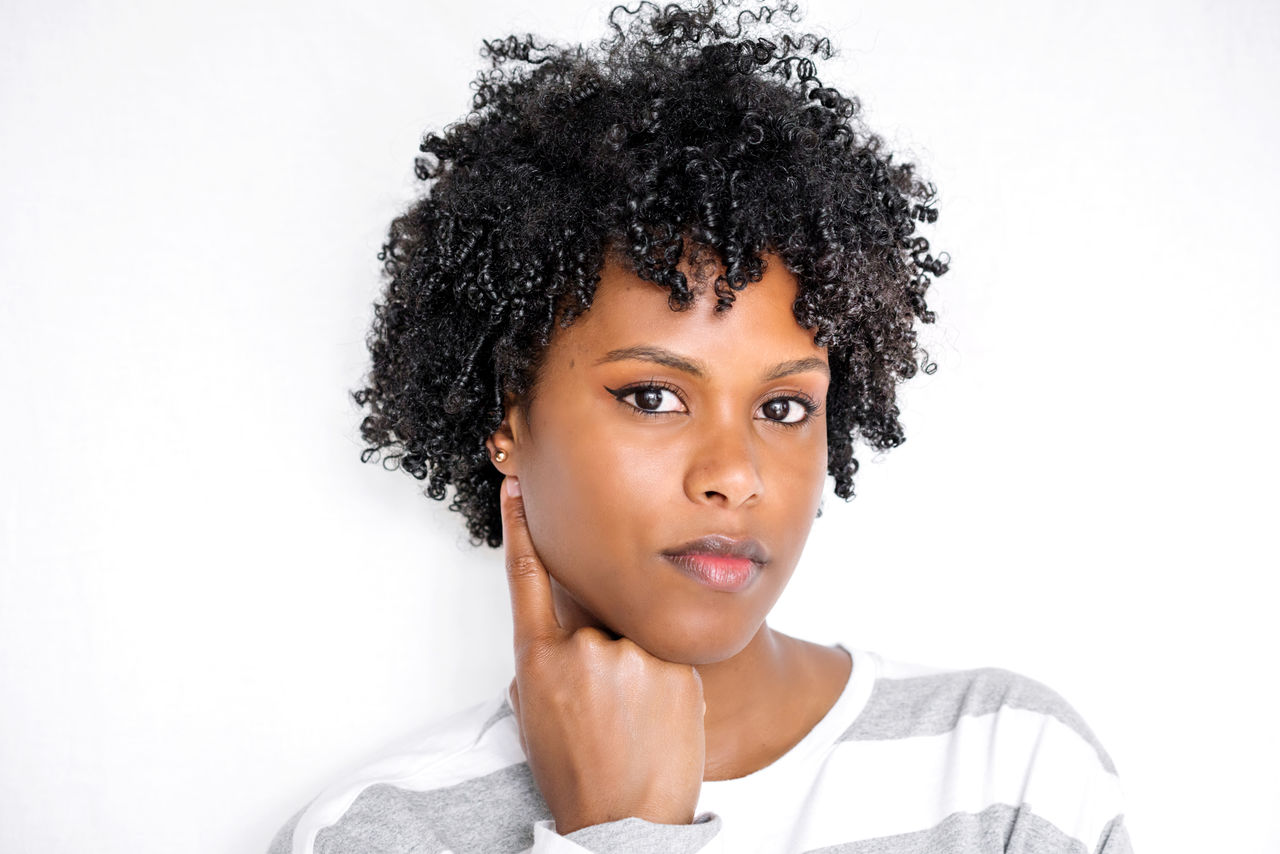 PORTRAIT OF BEAUTIFUL YOUNG WOMAN OVER WHITE BACKGROUND