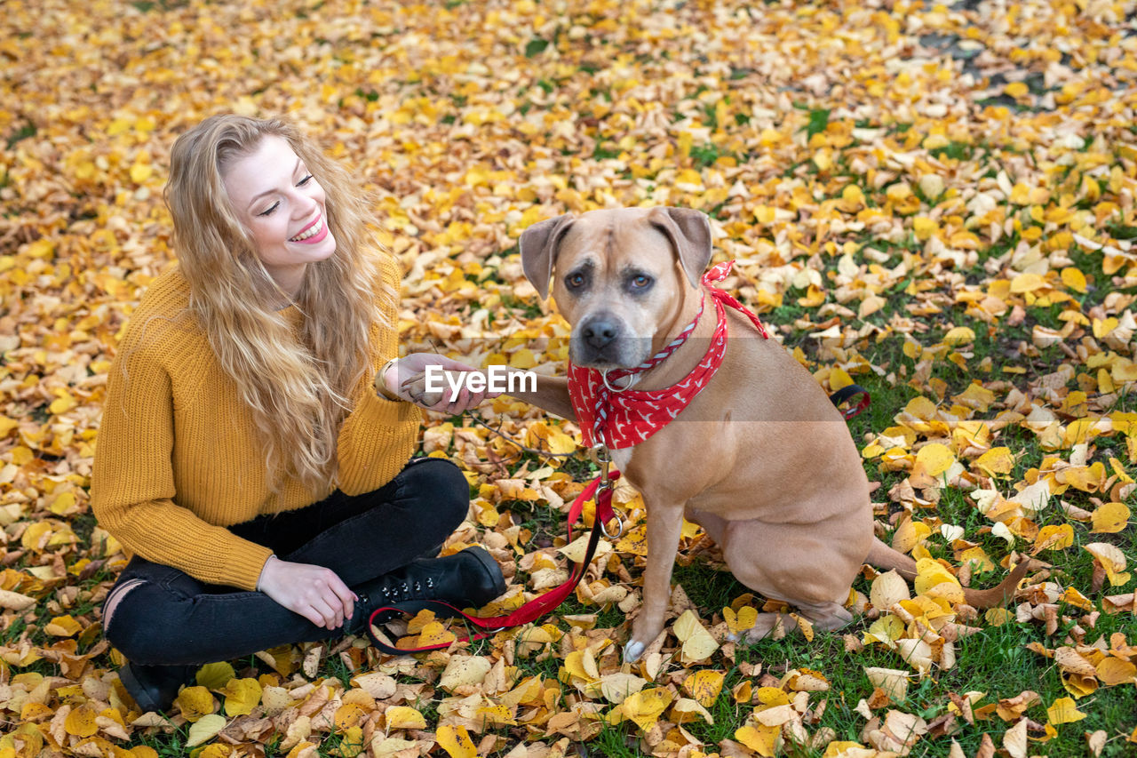 WOMAN WITH DOG IN AUTUMN LEAVES