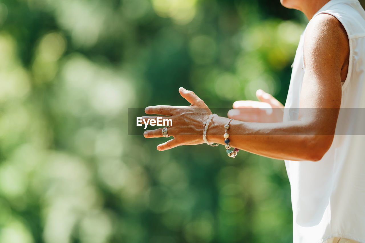 Woman practicing tai chi chuan outdoors. close up on hand position