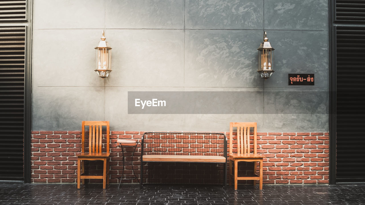 EMPTY CHAIRS AND TABLES AGAINST BUILDING