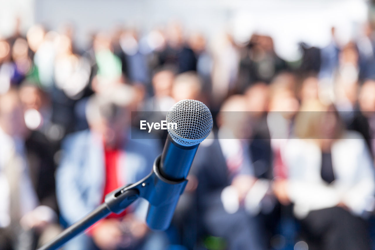 Close-up of microphone against crowd during event