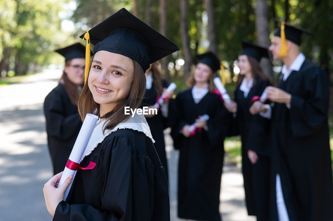 portrait of woman wearing graduation gown standing in traditional clothing