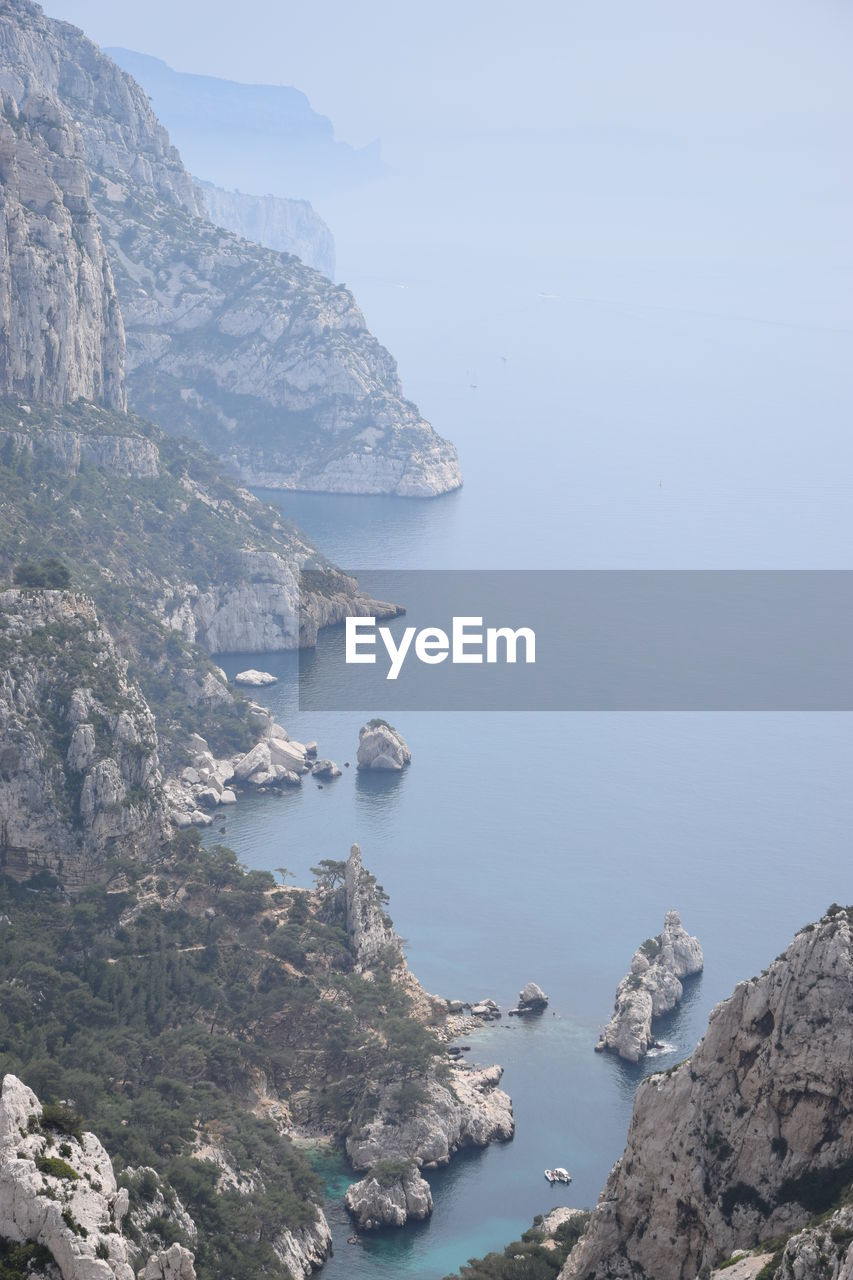 Scenic view of sea and mountains against sky