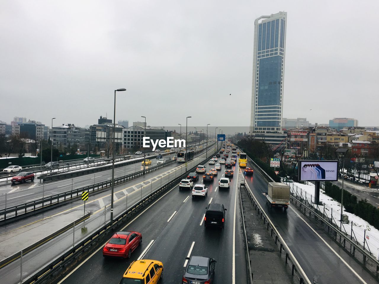 HIGH ANGLE VIEW OF TRAFFIC ON CITY STREET AGAINST SKY