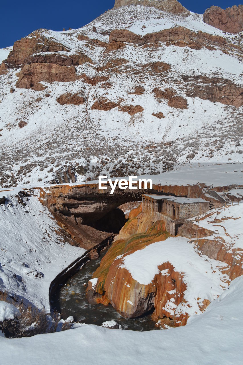 Built structure on snow covered rock