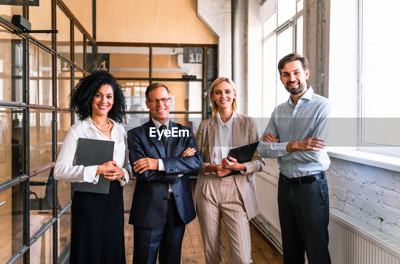 portrait of smiling business colleagues working at airport