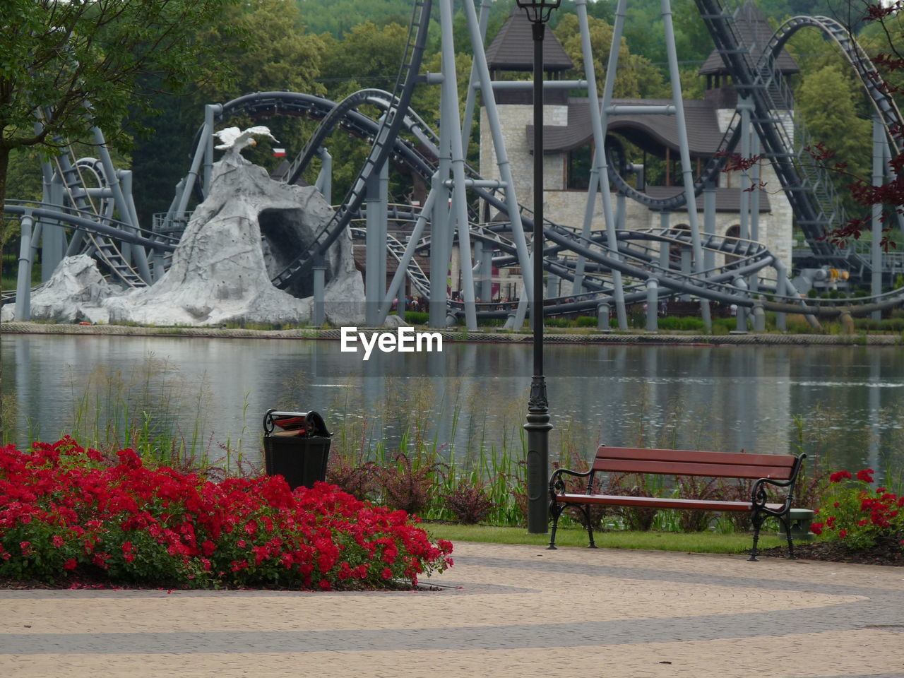 VIEW OF PARK BENCH BY LAKE AGAINST WALL