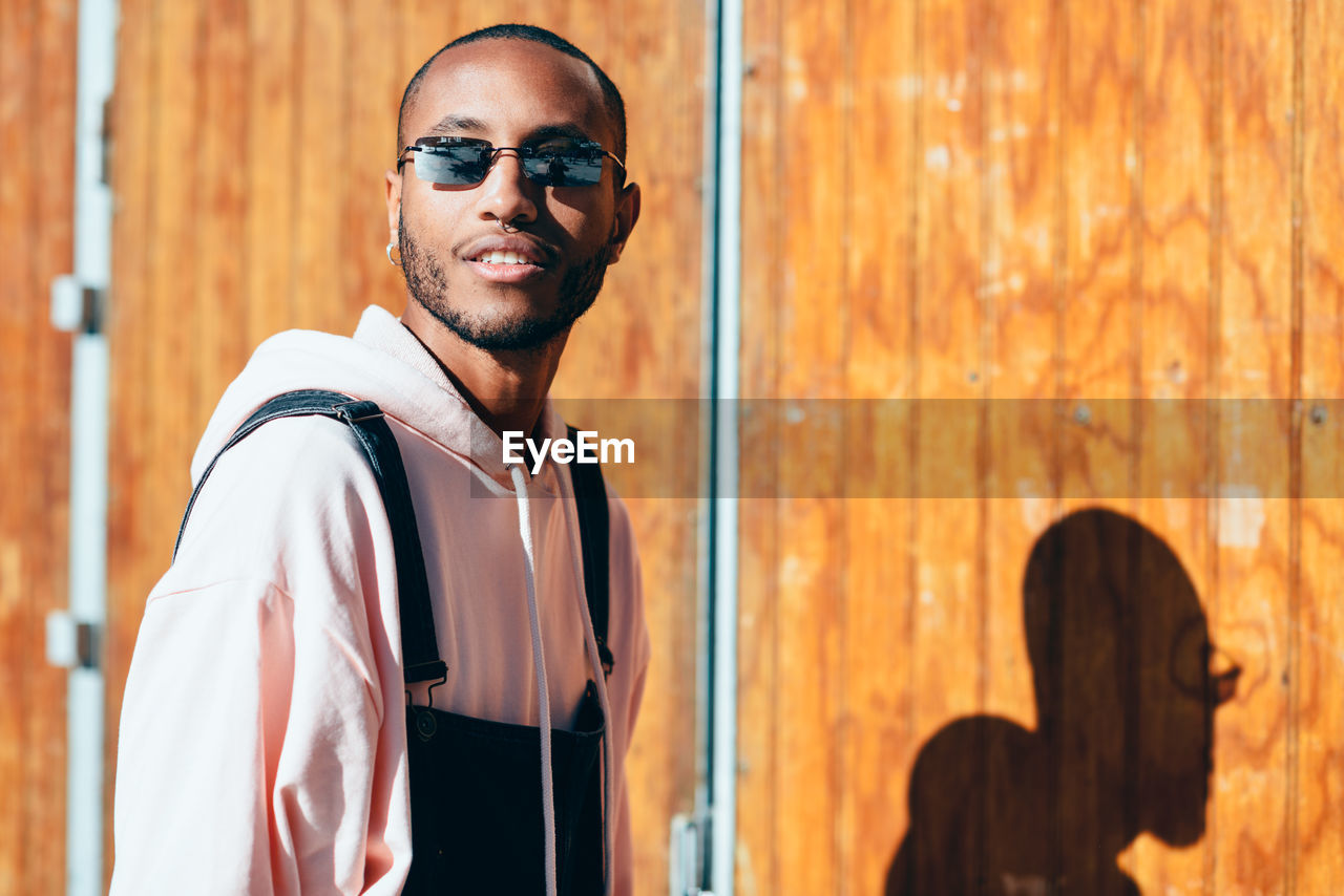 Portrait of young man wearing sunglasses while standing outdoors