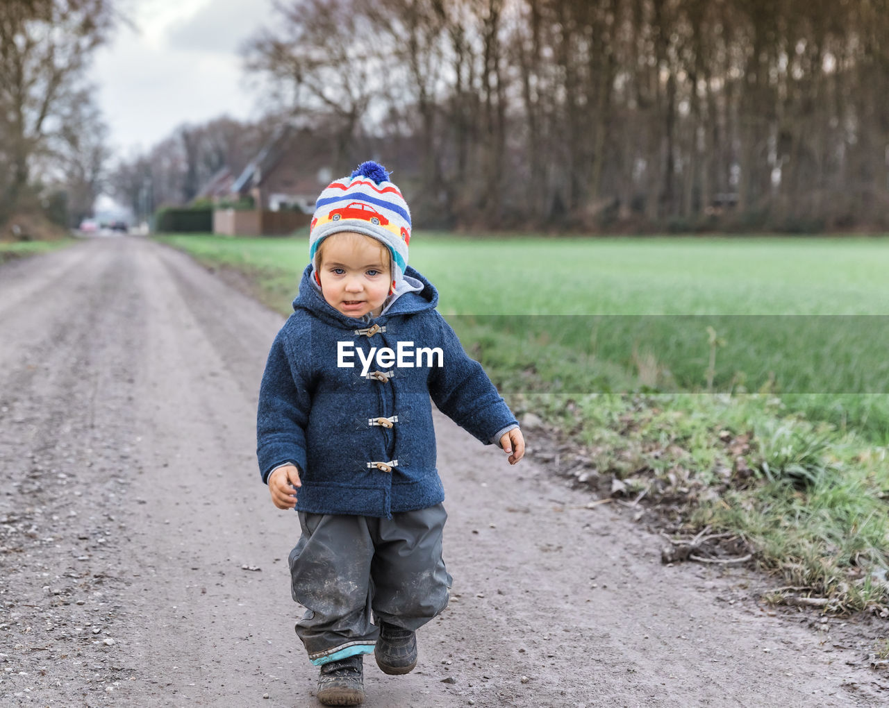 Full length of cute baby girl walking on dirt road