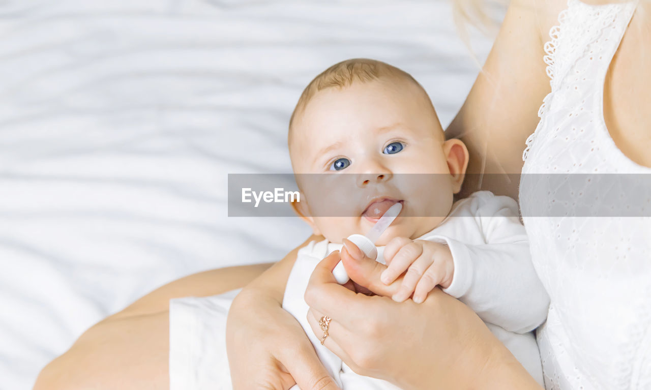 baby, child, childhood, portrait, two people, women, emotion, indoors, person, bed, adult, positive emotion, cute, happiness, family, looking at camera, parent, togetherness, innocence, toddler, smiling, love, female, furniture, portrait photography, skin, lifestyles, lying down, beginnings, white, one parent, care, bedroom, clothing, domestic room, holding, cheerful, bonding, men, baby clothing, babyhood, relaxation, headshot, bride, domestic life