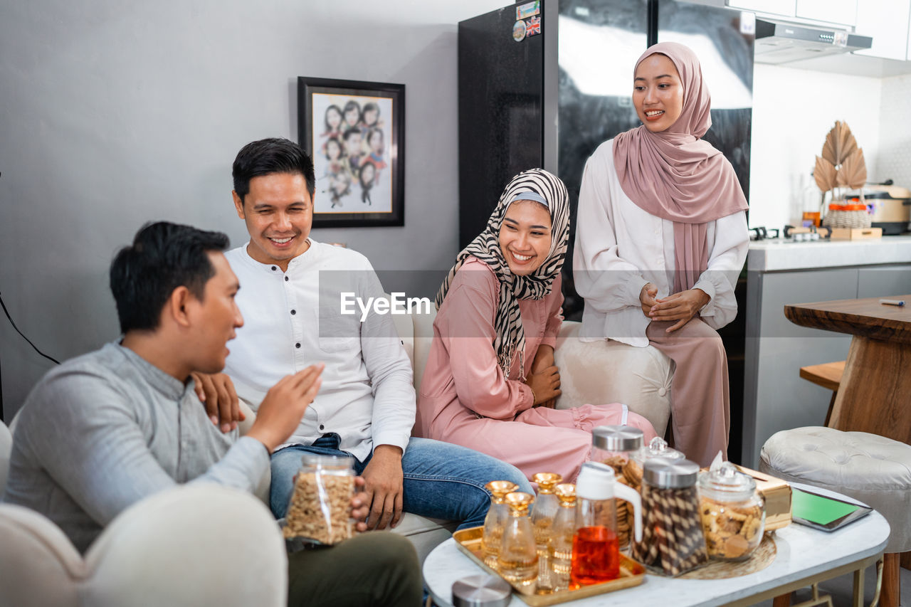 female friends sitting on table at home