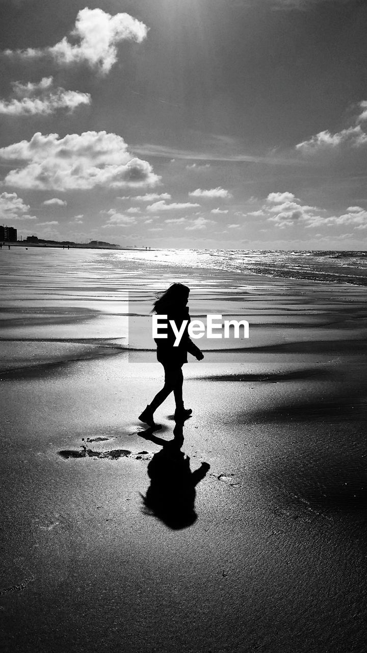 SIDE VIEW OF SILHOUETTE WOMAN STANDING ON BEACH