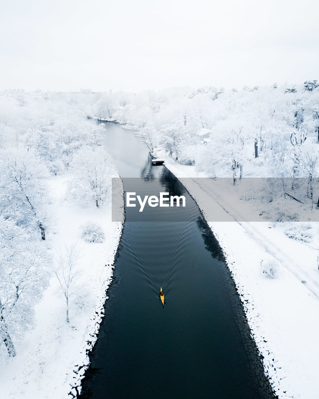 High angle view of river amidst snow covered field