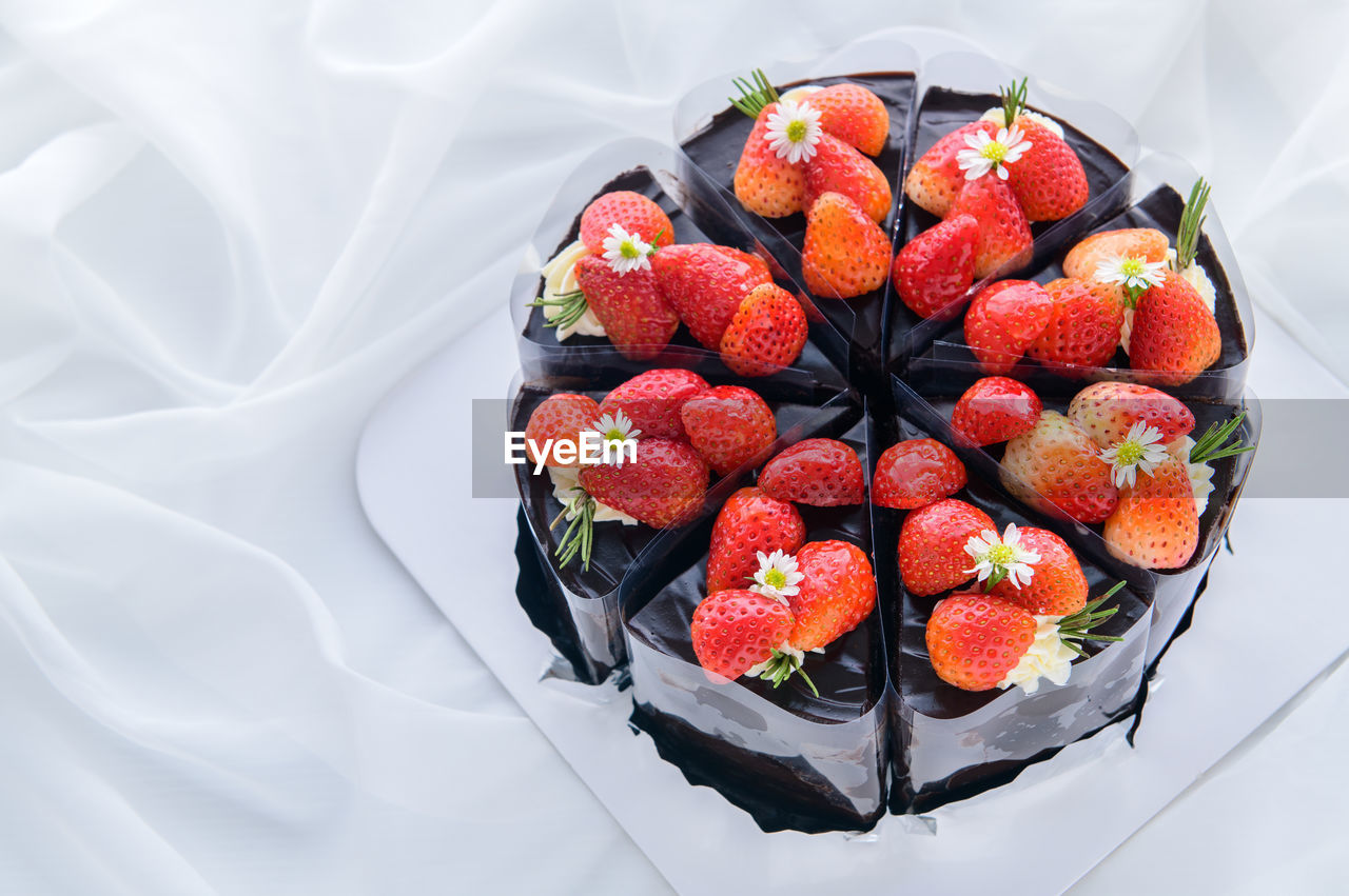 Chocolate cake decorated with fresh strawberry on white cloth,