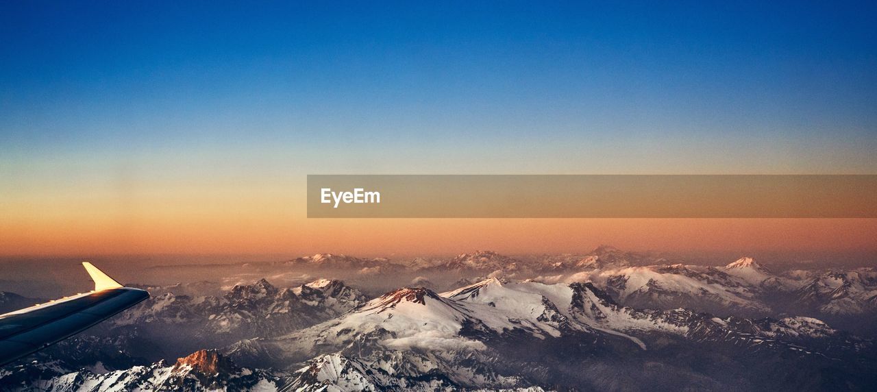 SCENIC VIEW OF SNOWCAPPED MOUNTAIN AGAINST SKY DURING SUNSET