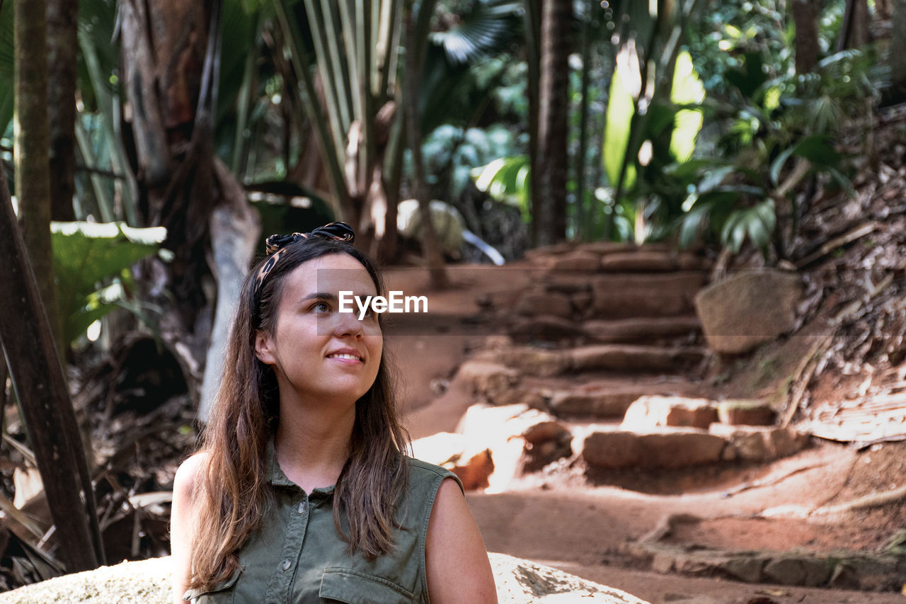 Portrait of an attractive young woman in tropical forest.