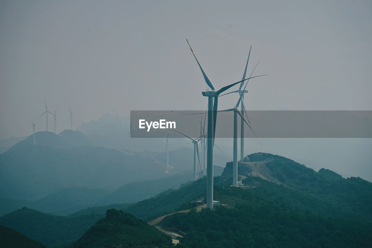 Windmill on mountain against sky