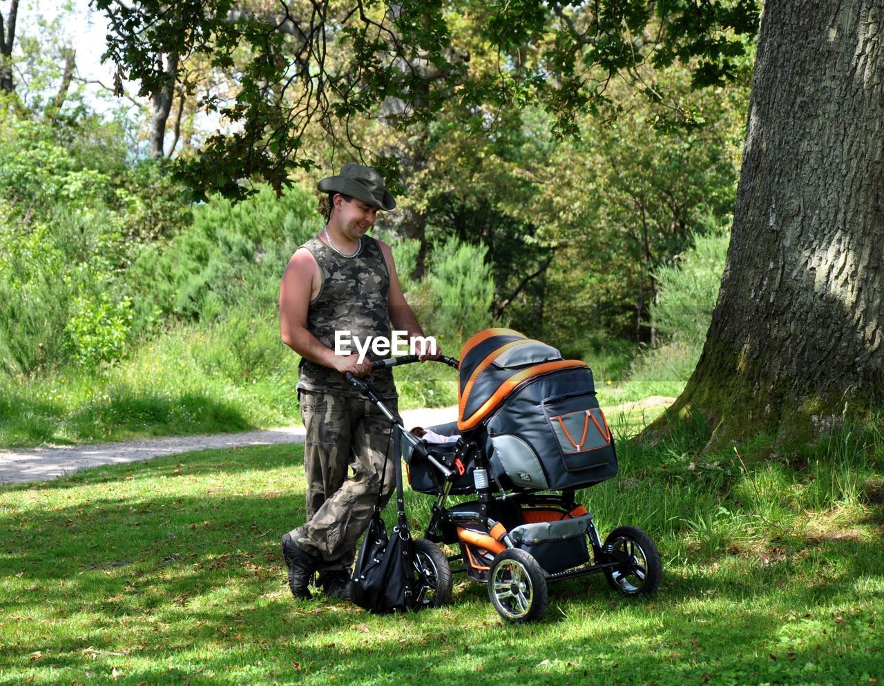 Man holding stroller on grass