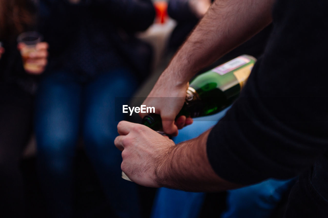 Cropped image of man hand pouring drink