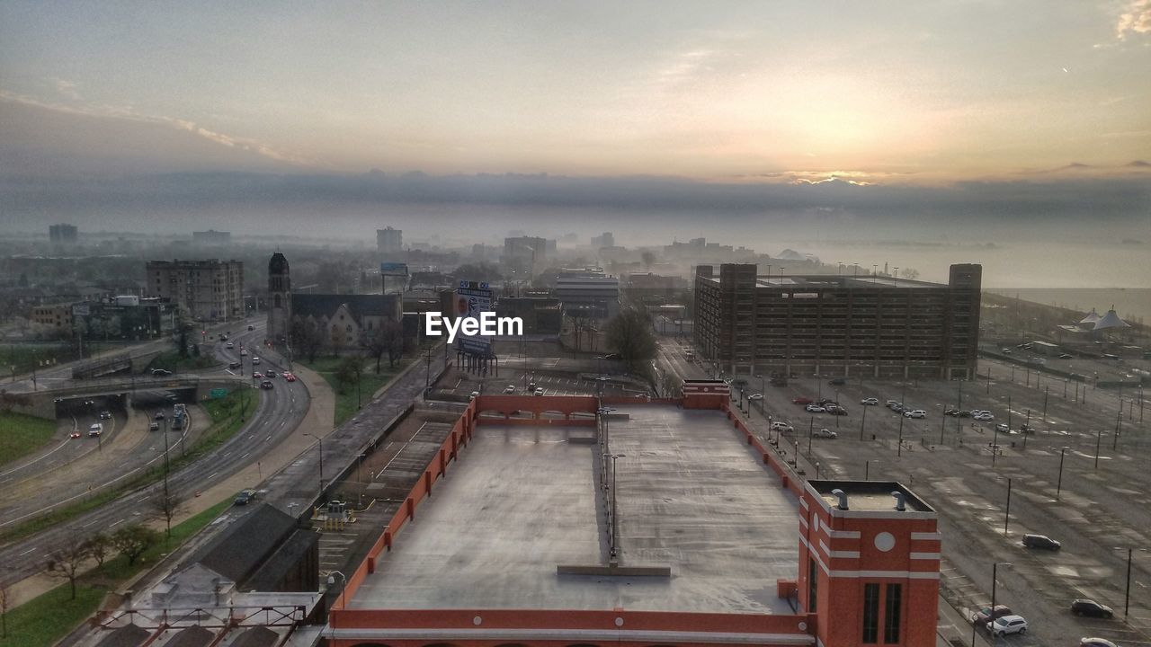 High angle view of parking lot in city against sky in foggy weather