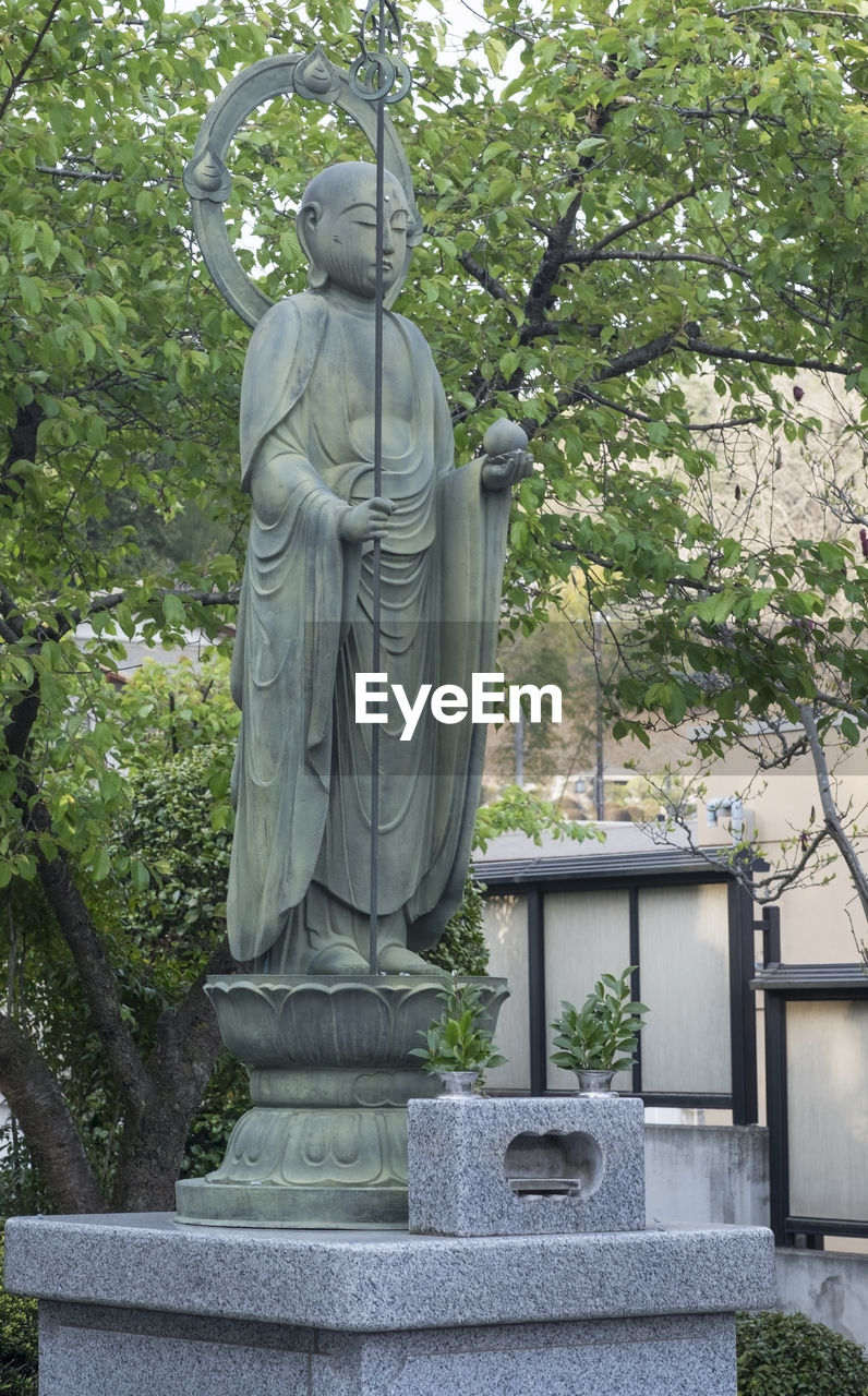 LOW ANGLE VIEW OF STATUE AGAINST TREES