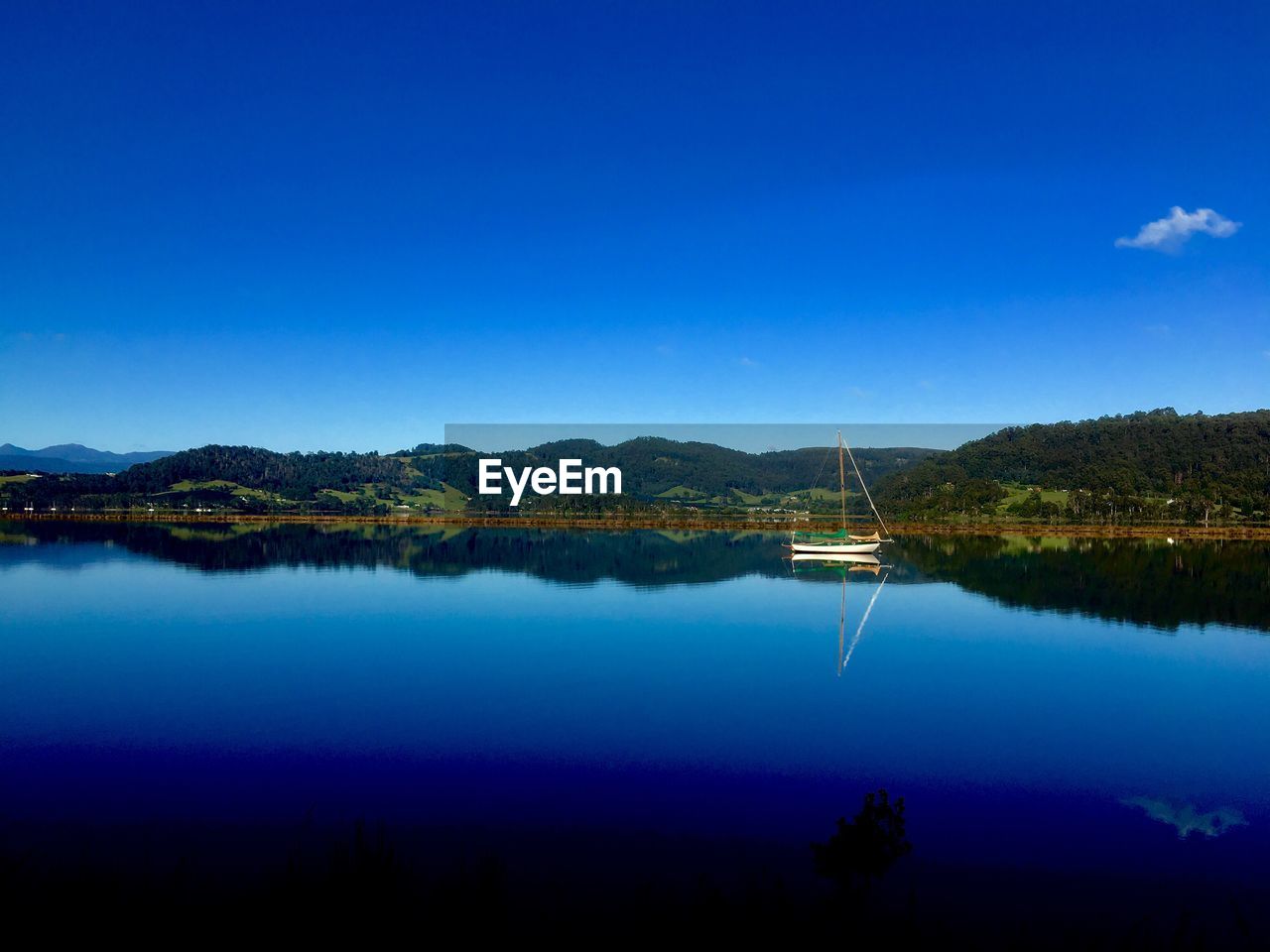 Scenic view of lake against blue sky