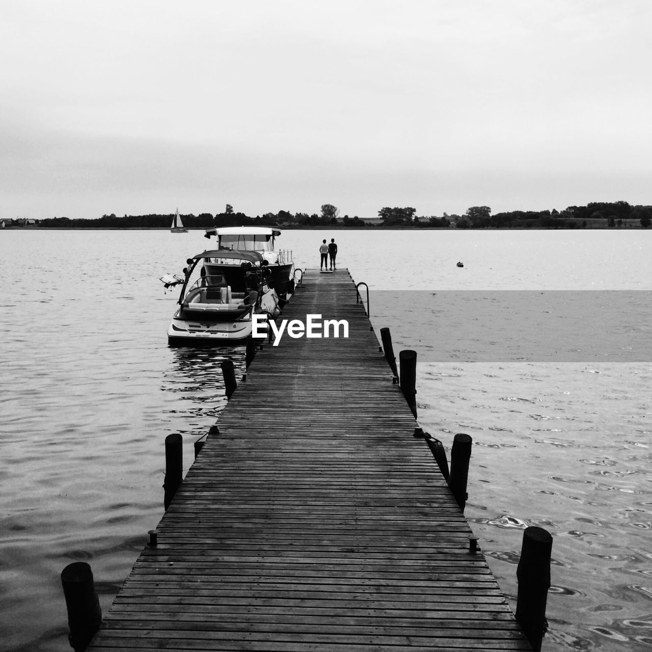 Boat moored by pier against clear sky