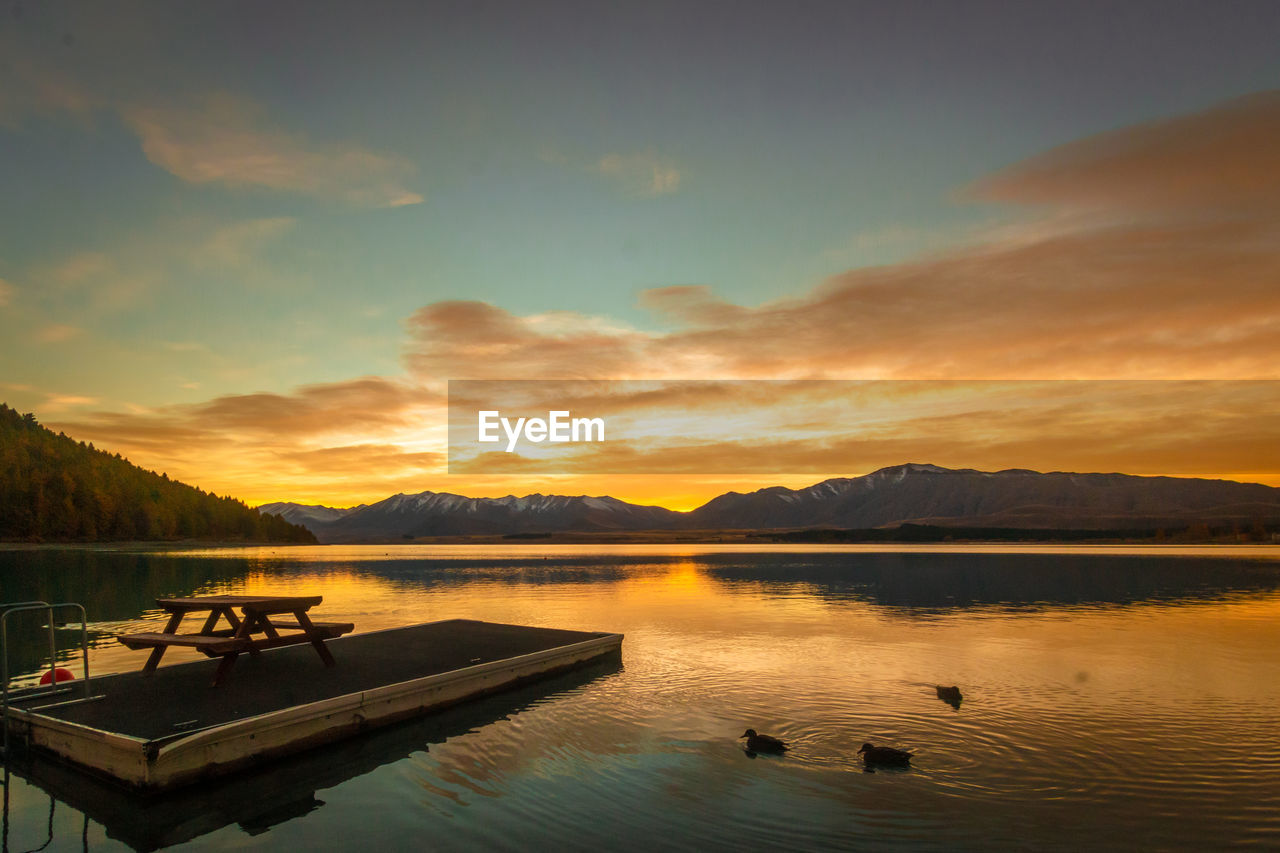 Scenic view of lake against sky during sunrise