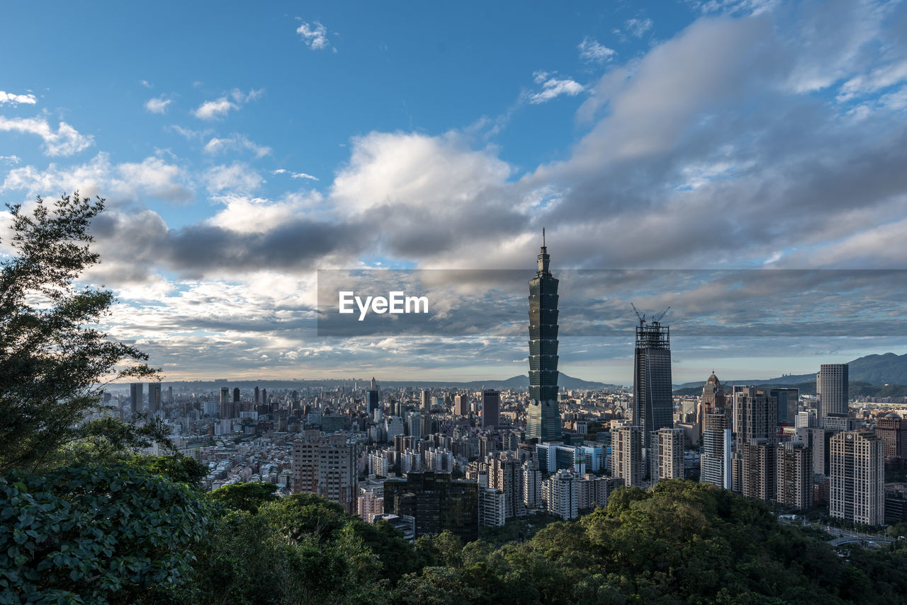 View of cityscape against cloudy sky