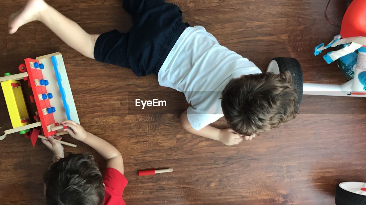 Directly above shot of children playing on floorboard