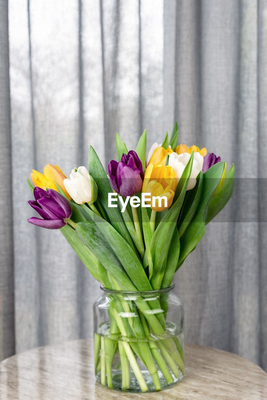 Bouquet of fresh bright colorful tulips on a side table.