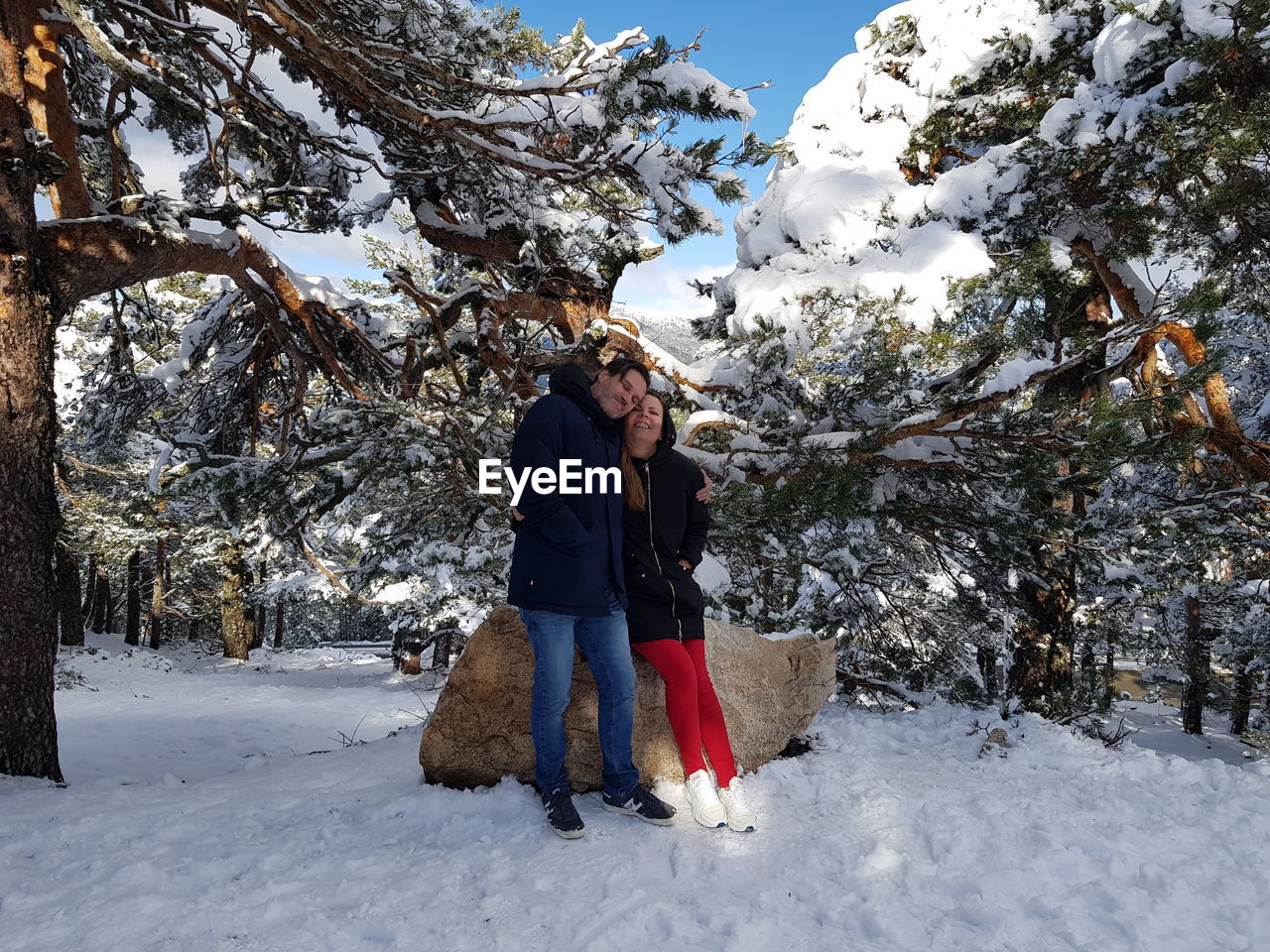 FULL LENGTH OF WOMAN STANDING ON SNOWCAPPED MOUNTAIN