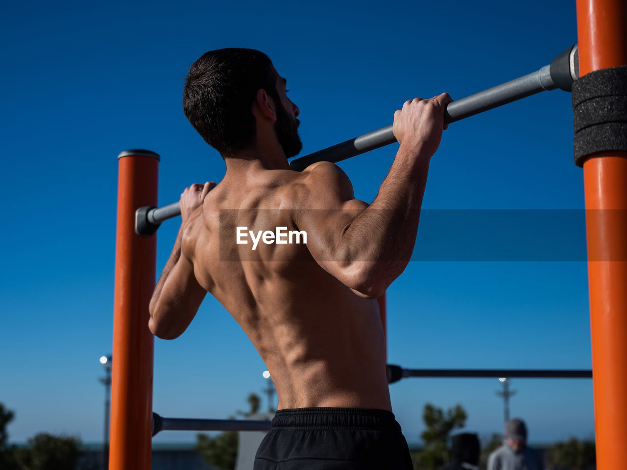 Side view of young man standing against sky