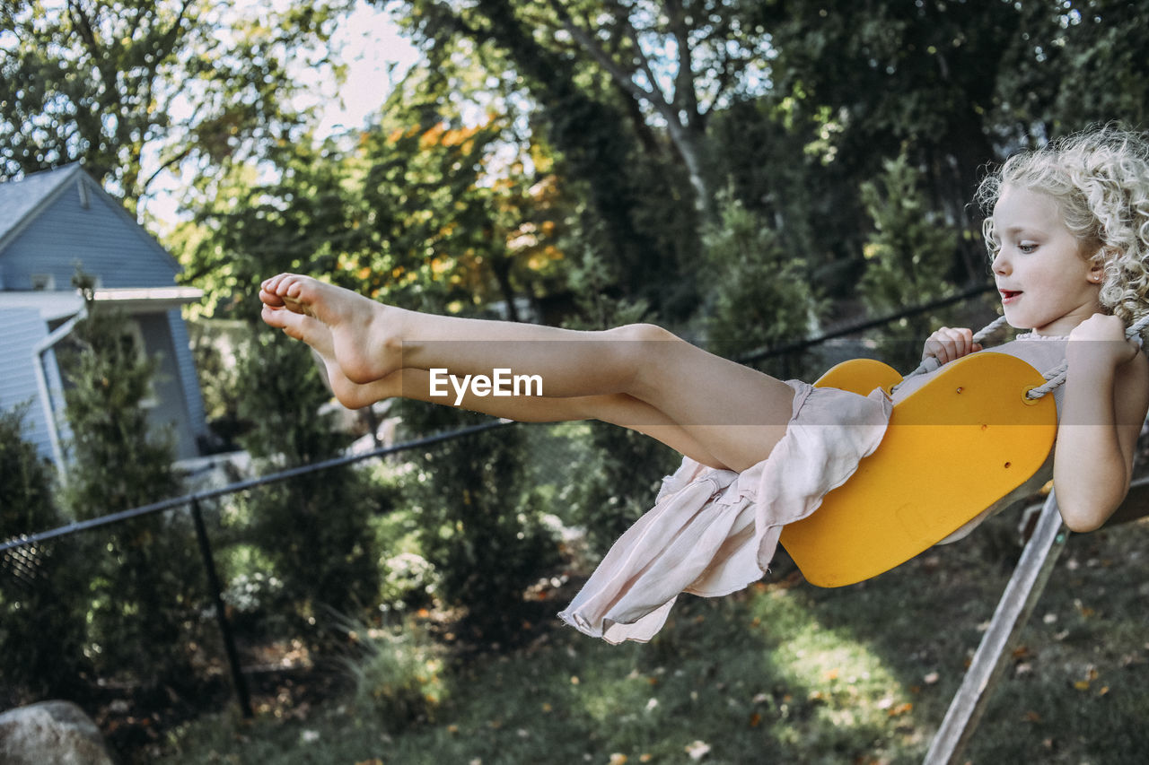 Side view of girl swinging at playground