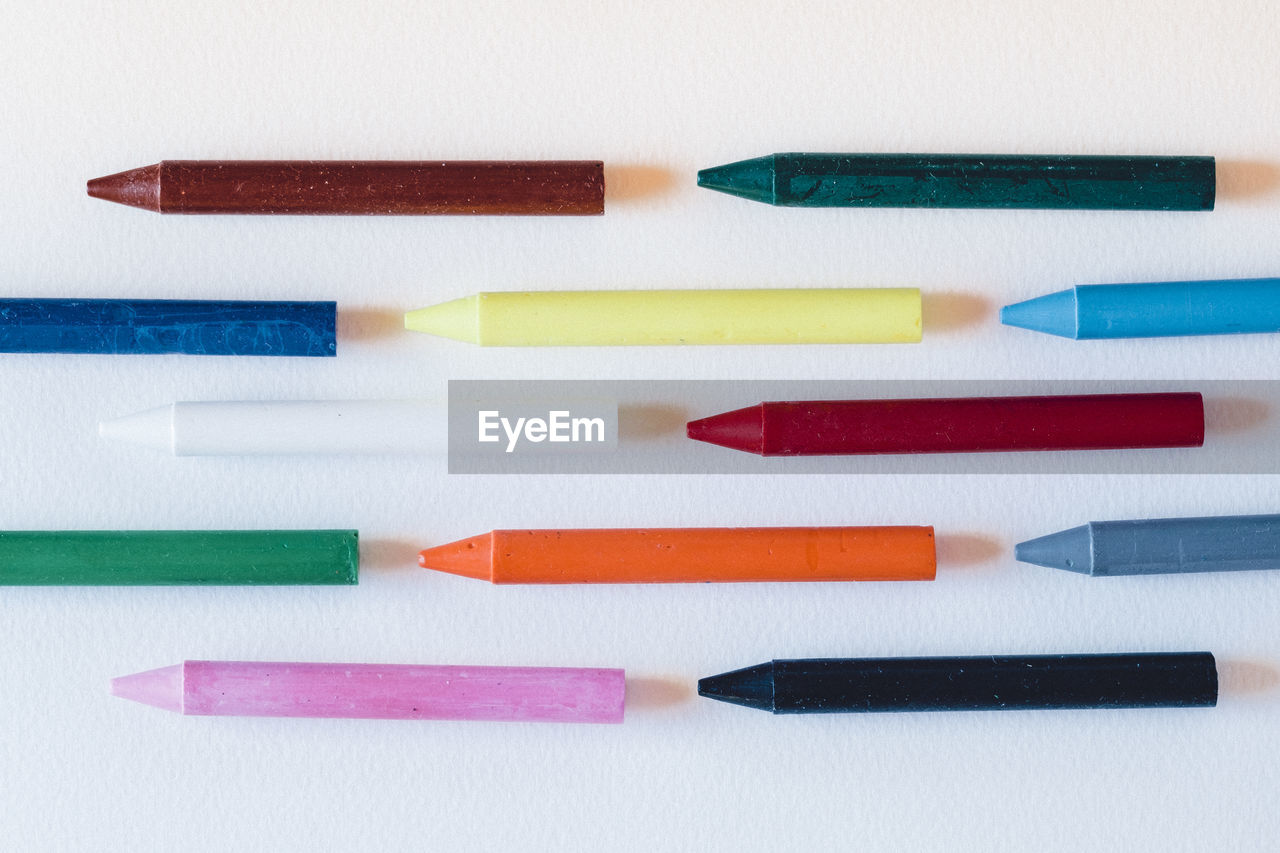 Directly above view of colorful crayons on white background