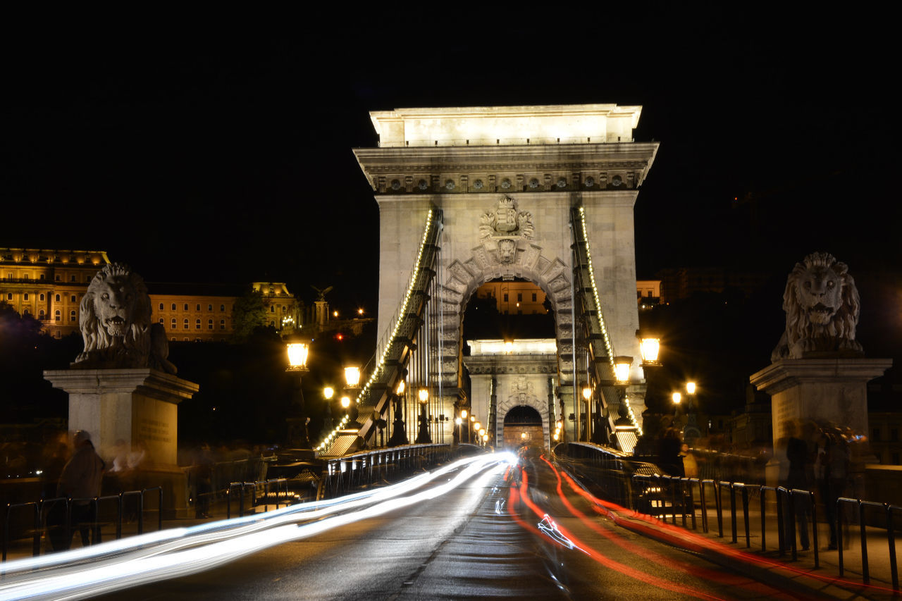 Light trails on chain bridge against clear sky