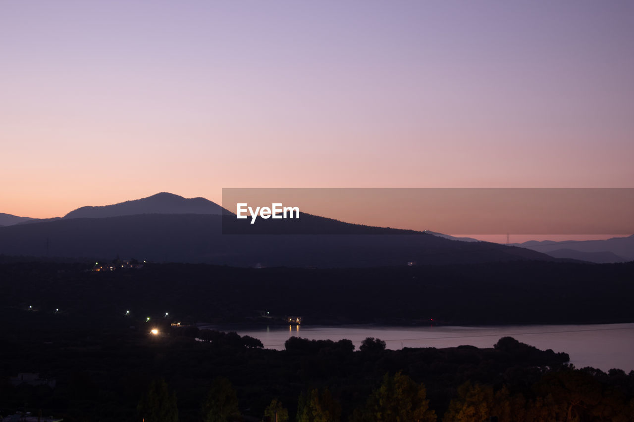 mountain, sky, dawn, scenics - nature, beauty in nature, sunrise, water, nature, environment, morning, landscape, horizon, tranquility, mountain range, no people, tranquil scene, lake, afterglow, land, silhouette, travel destinations, travel, highland, outdoors, sun, cloud, twilight, architecture, copy space, idyllic, plant, tourism, city, reflection