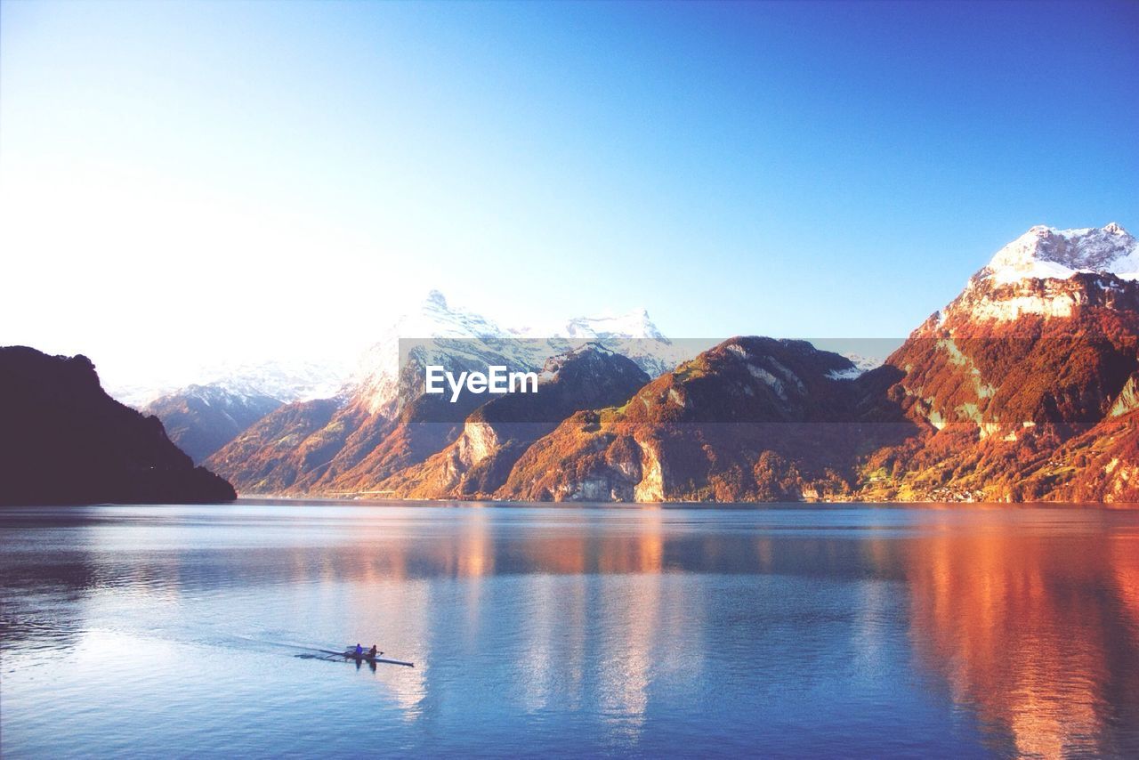 Scenic view of mountains and lake against clear sky