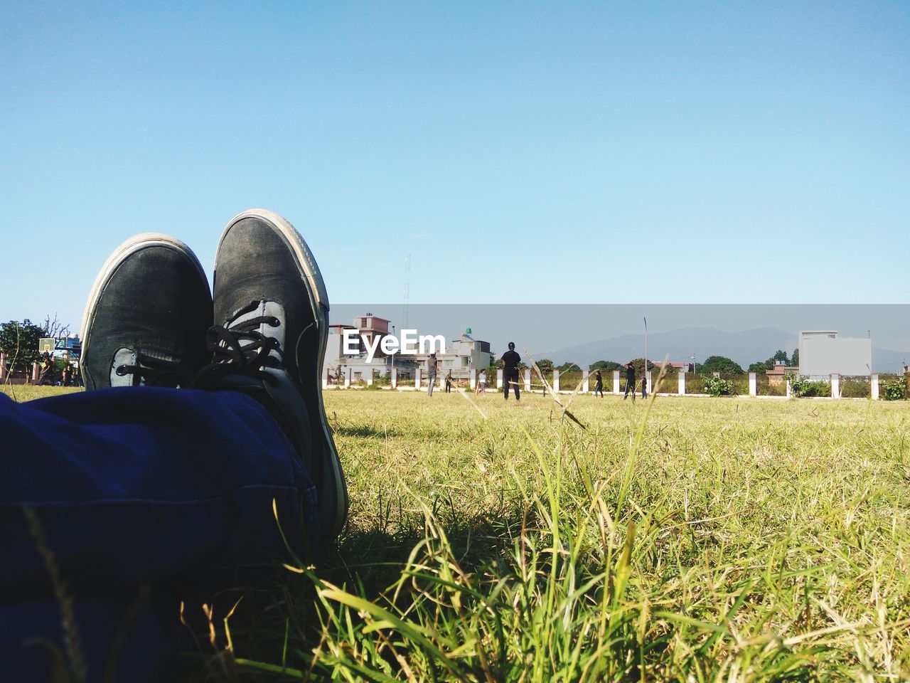 PANORAMIC SHOT OF PEOPLE ON FIELD AGAINST CLEAR SKY