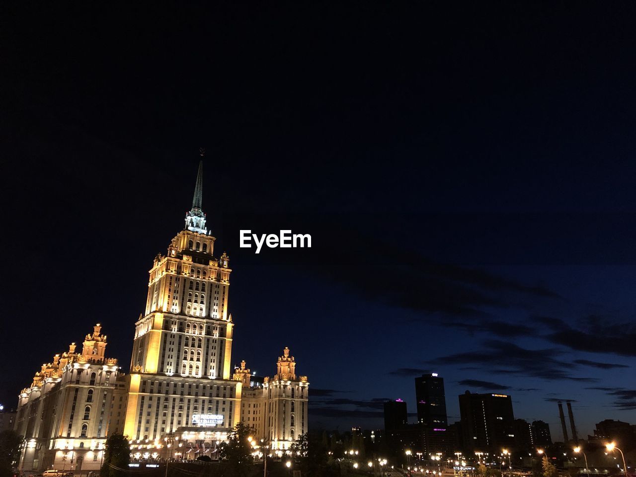 LOW ANGLE VIEW OF ILLUMINATED BUILDINGS AT NIGHT