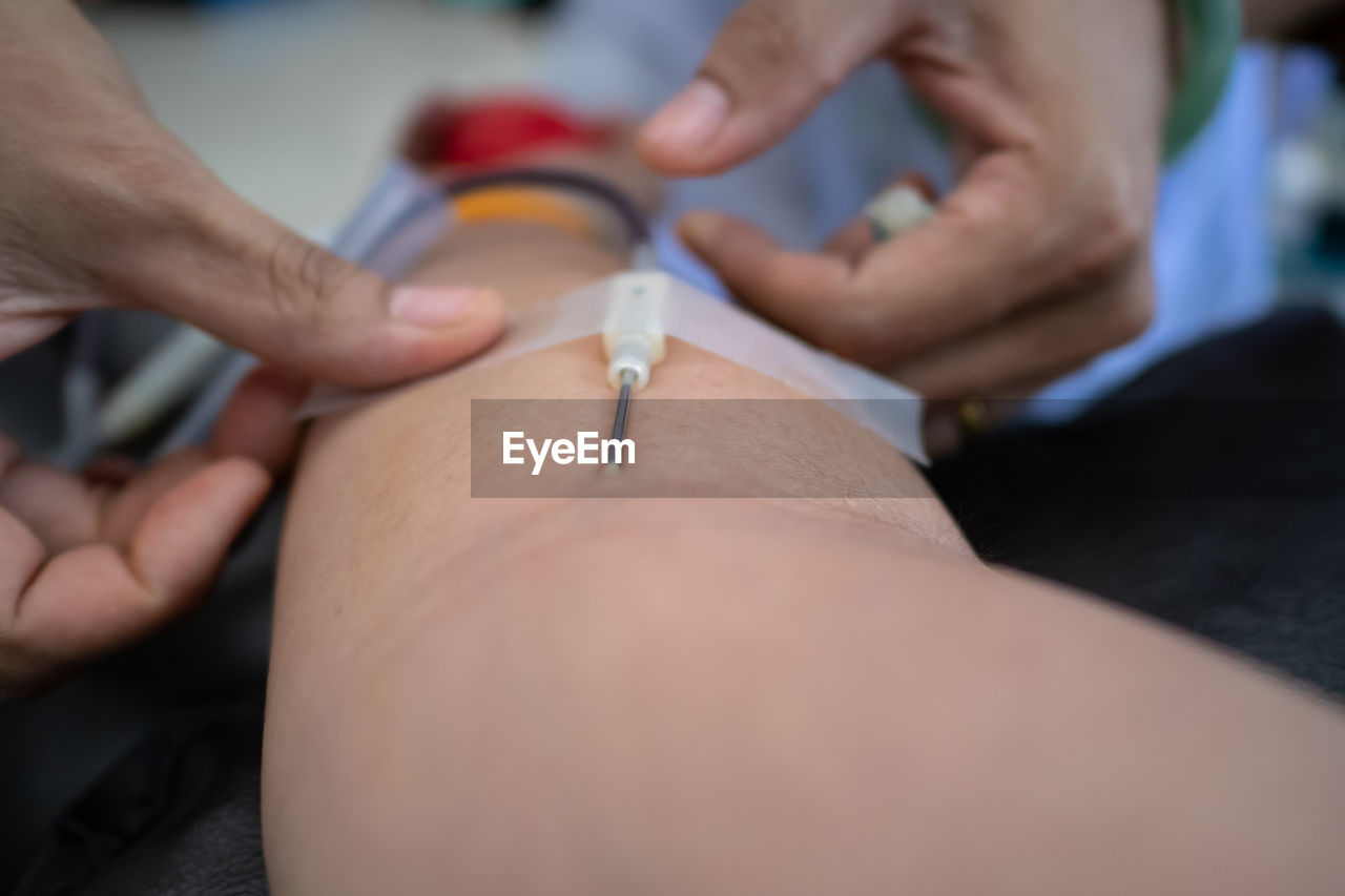 Close-up of doctor injecting syringe on patient hand