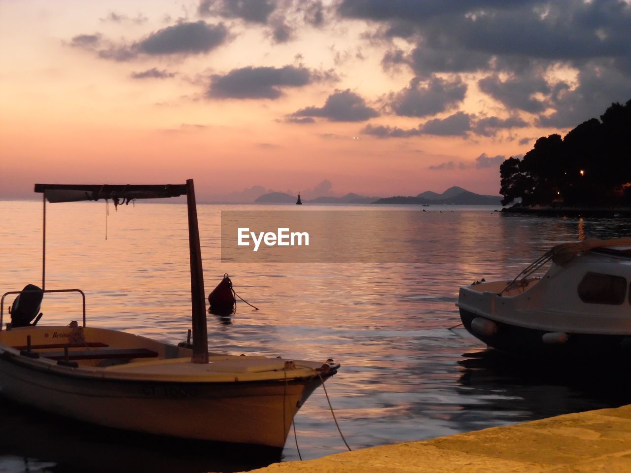 Boat sailing on sea against sky during sunset