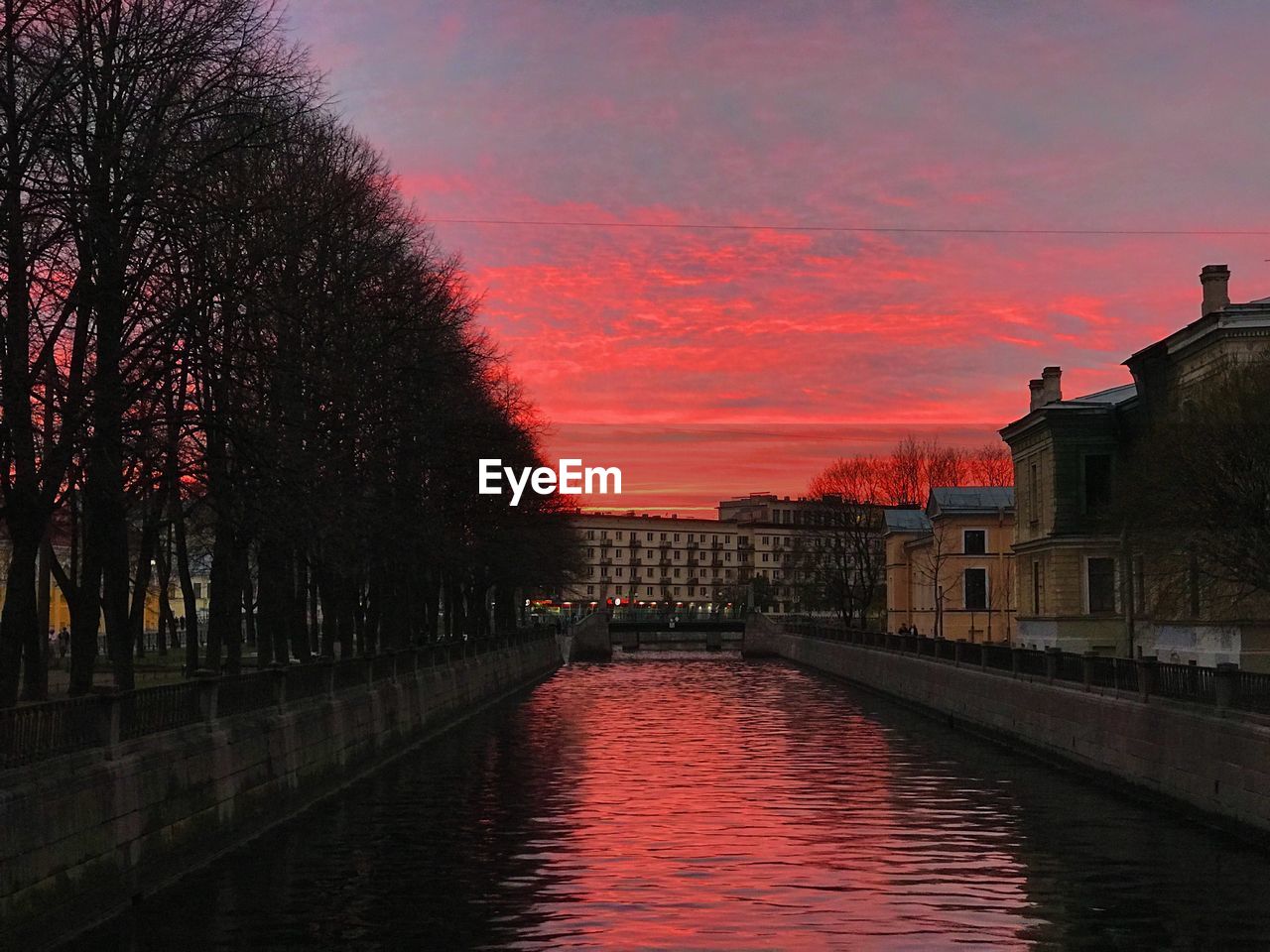 CANAL BY BUILDINGS AGAINST SKY DURING SUNSET