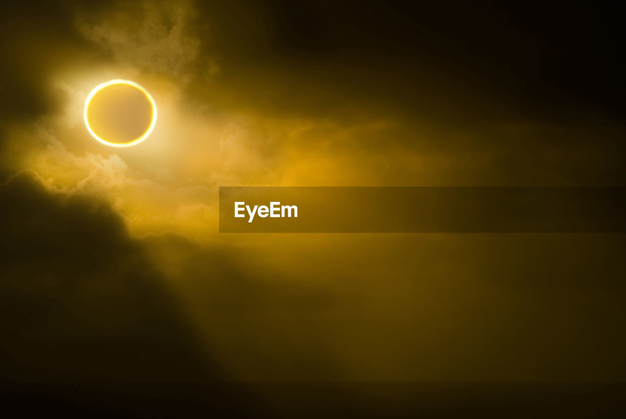 Low angle view of solar eclipse in sky during foggy weather