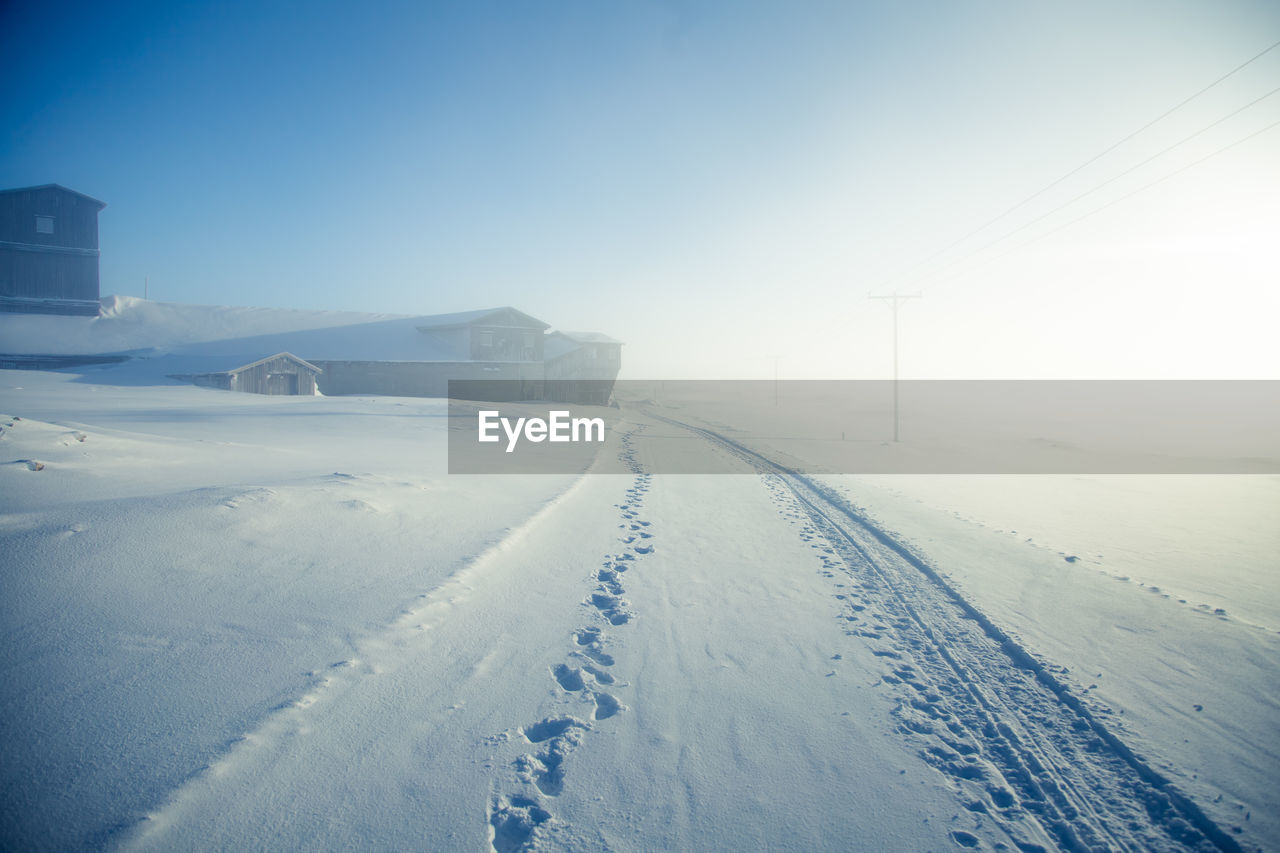 Snow covered land against sky