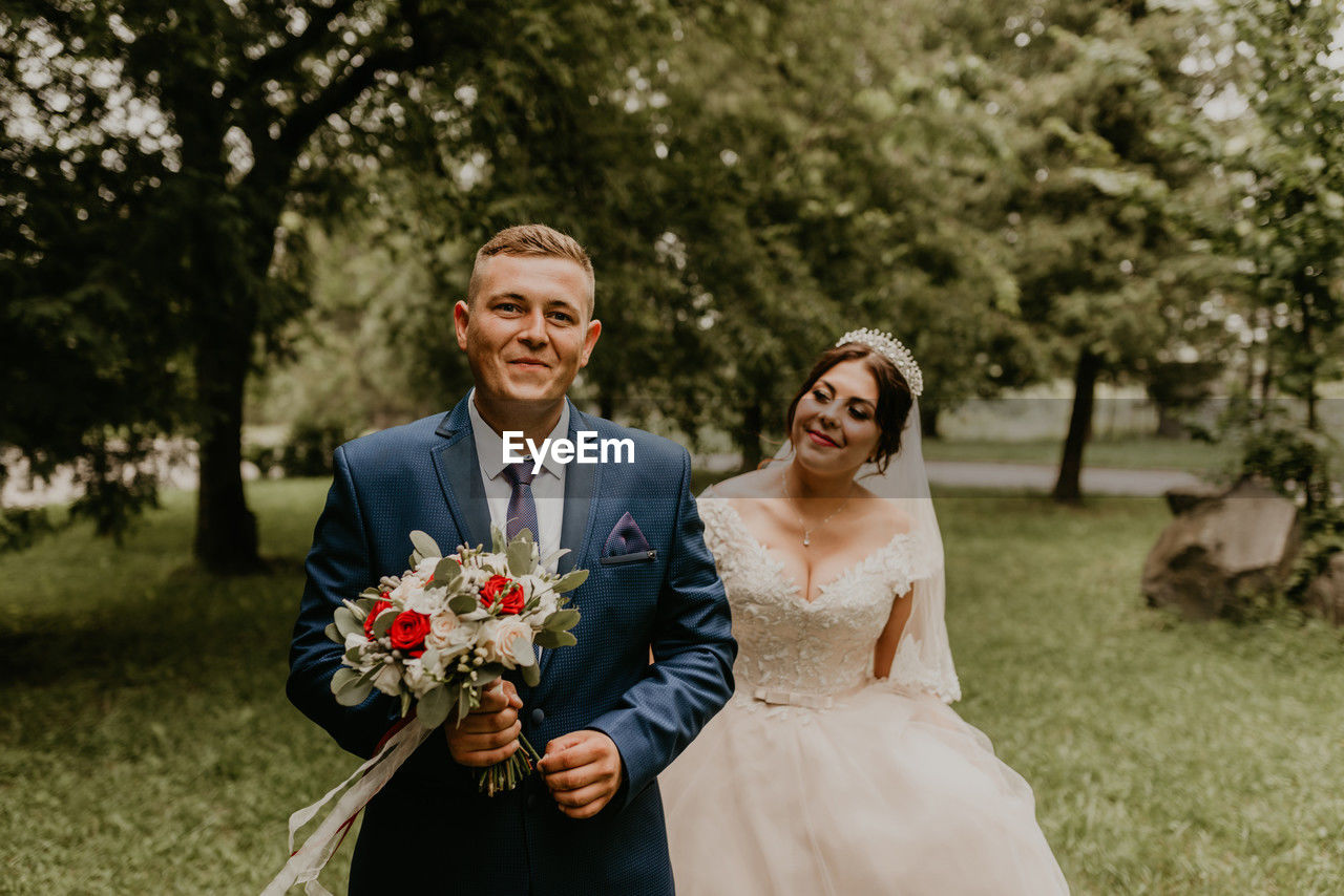 portrait of bride and bridegroom holding bouquet