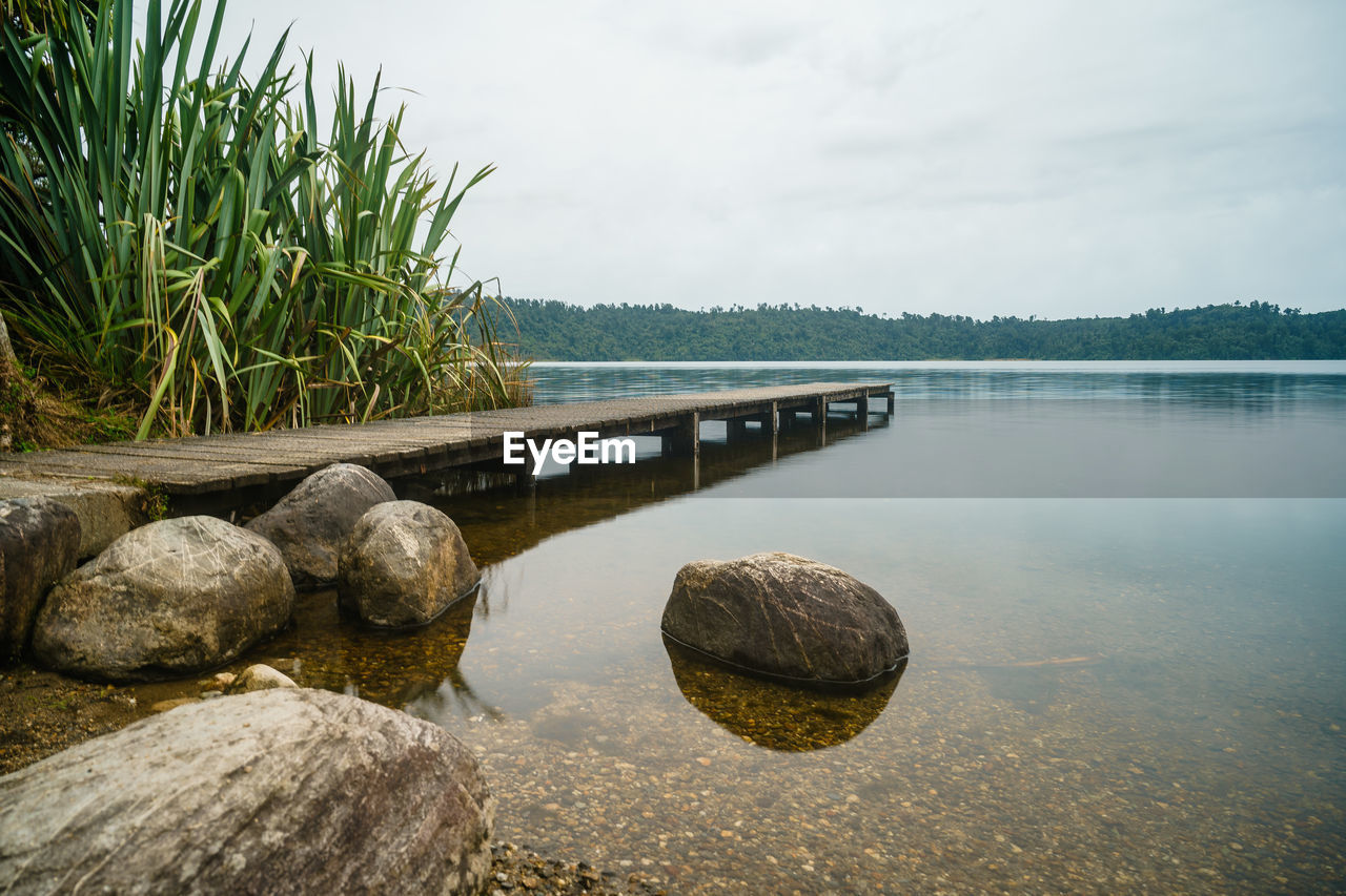 STONES BY LAKE AGAINST SKY