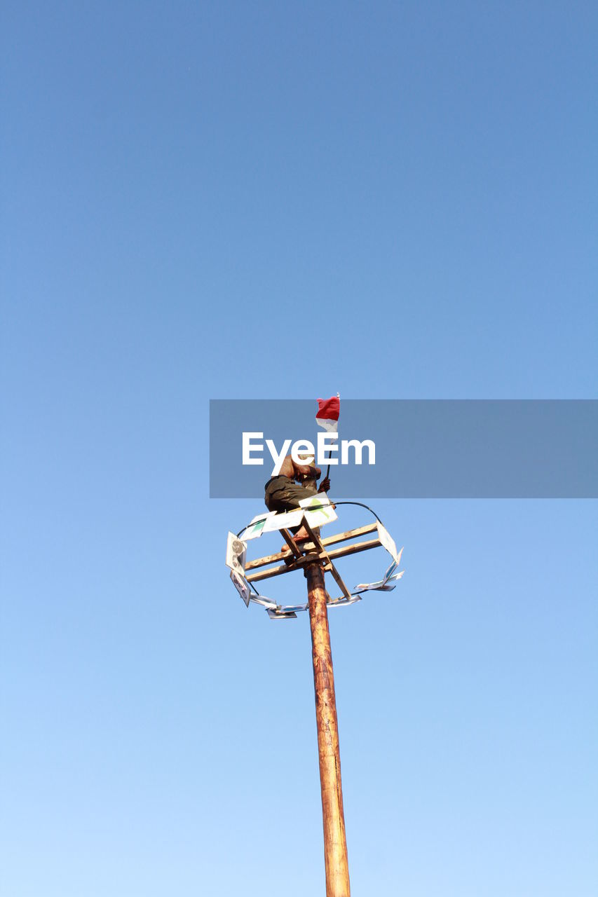 LOW ANGLE VIEW OF POLE AGAINST CLEAR SKY