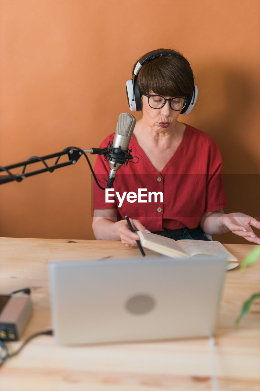 young man using mobile phone while sitting on table