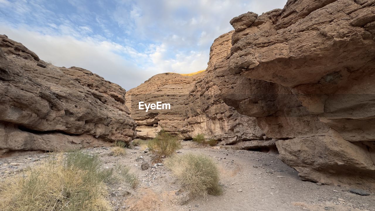 rock, landscape, environment, scenics - nature, rock formation, sky, nature, wadi, valley, beauty in nature, land, cloud, desert, travel destinations, non-urban scene, travel, geology, no people, mountain, climate, wilderness, tranquility, arid climate, canyon, extreme terrain, outdoors, semi-arid, terrain, plant, cliff, physical geography, eroded, day, tourism, tranquil scene, accidents and disasters, arch, mountain range, plateau, dry, formation, remote